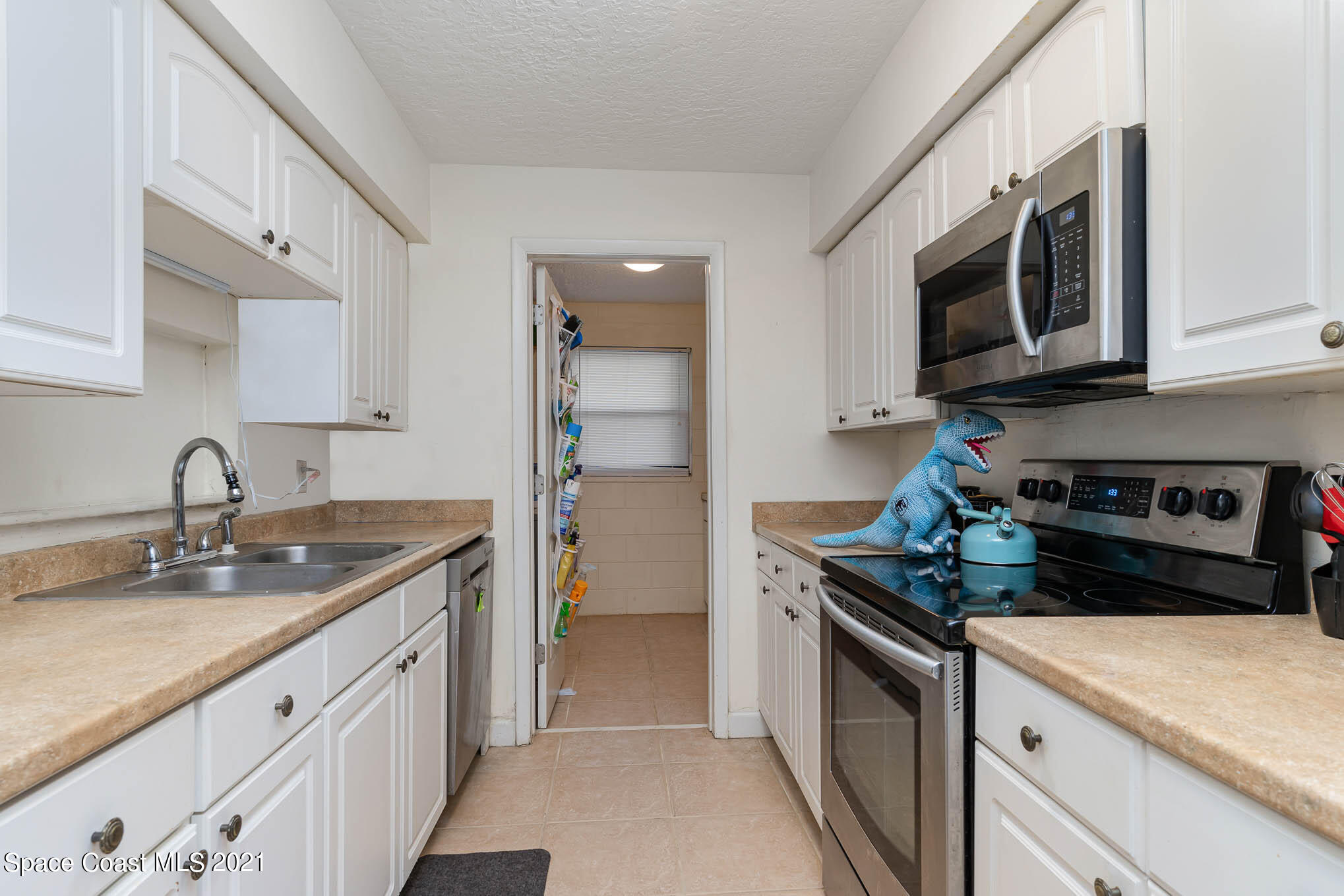 2285 Dolphin Road Titusville, FL 32780 - Photo 13 of 27 a kitchen with stainless steel appliances granite countertop a sink stove and refrigerator