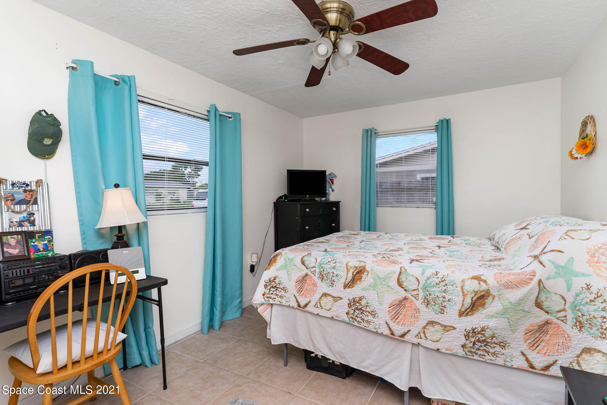2285 Dolphin Road Titusville, FL 32780 - Photo 22 of 27 a bedroom with a bed a dresser and potted plants