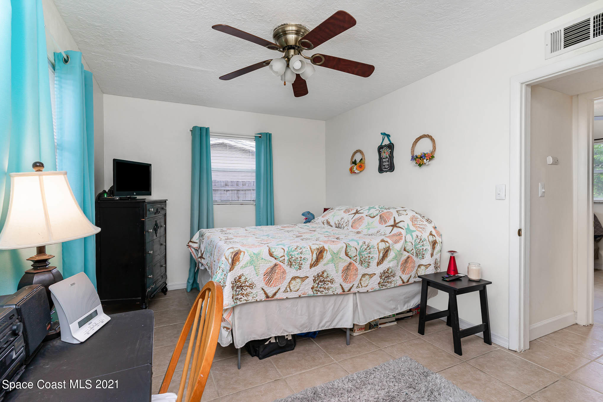 2285 Dolphin Road Titusville, FL 32780 - Photo 24 of 27 a bedroom with a bed and a chandelier