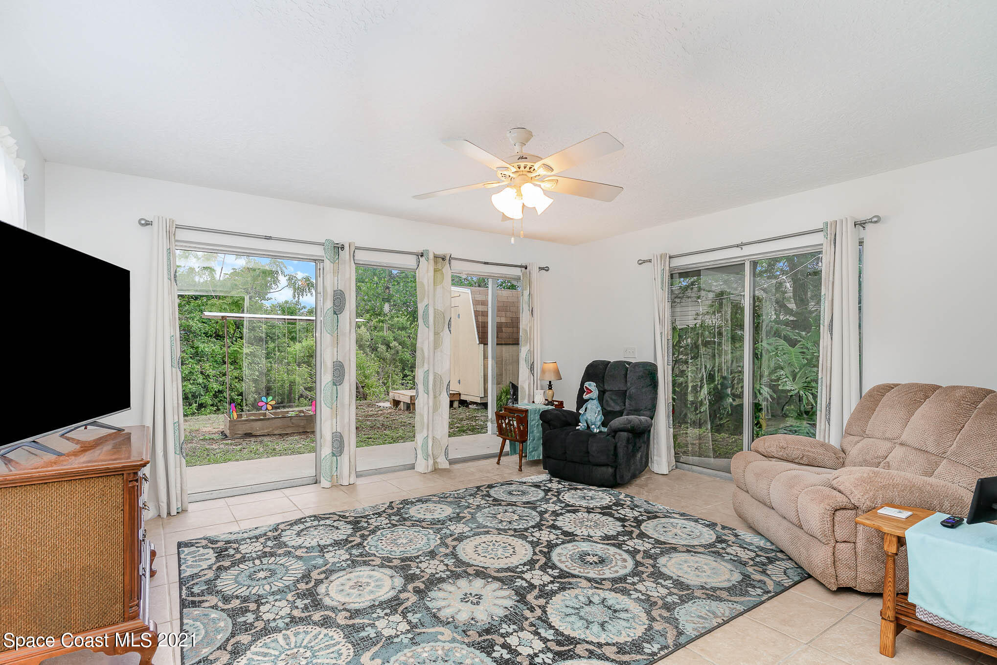 2285 Dolphin Road Titusville, FL 32780 - Photo 26 of 27 a living room with furniture tv and a flat screen tv