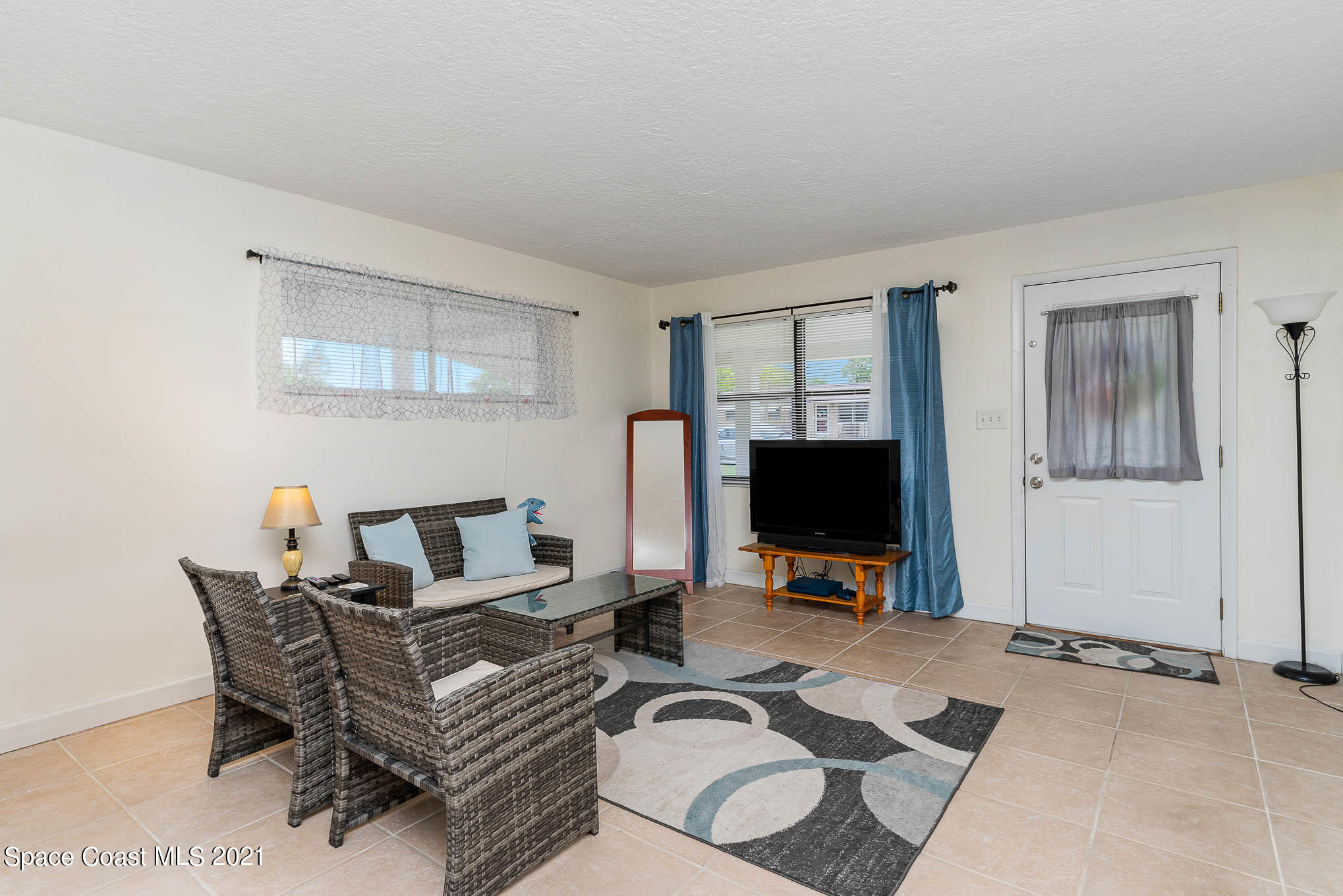 2285 Dolphin Road Titusville, FL 32780 - Photo 9 of 27 a living room with furniture a flat screen tv and a window