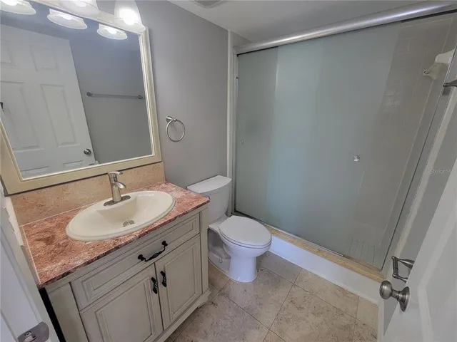 a bathroom with a granite countertop sink toilet and shower