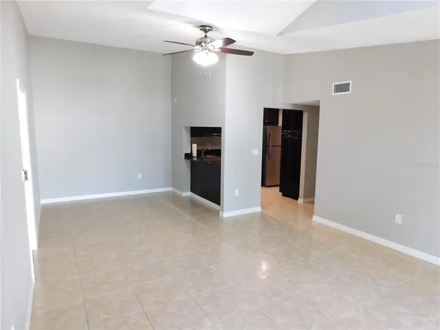 an empty room with closet and a ceiling fan