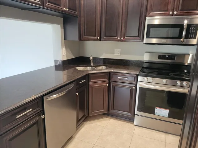 a kitchen with stainless steel appliances granite countertop a sink and a stove