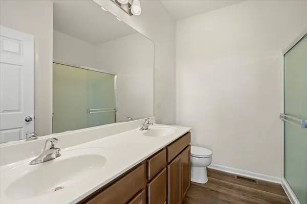 a bathroom with a sink a toilet and shower