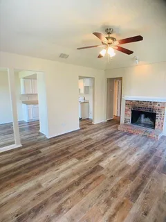 a view of an empty room with window and wooden floor