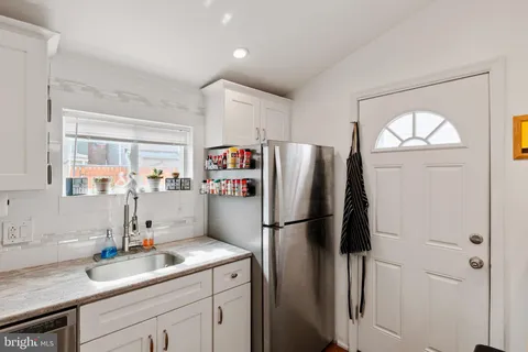 a kitchen with a refrigerator sink and cabinets