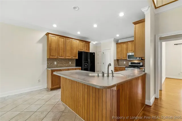 a kitchen with stainless steel appliances granite countertop a sink a stove and a refrigerator