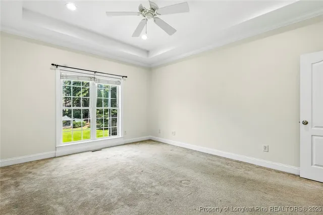 an empty room with a ceiling fan and a window