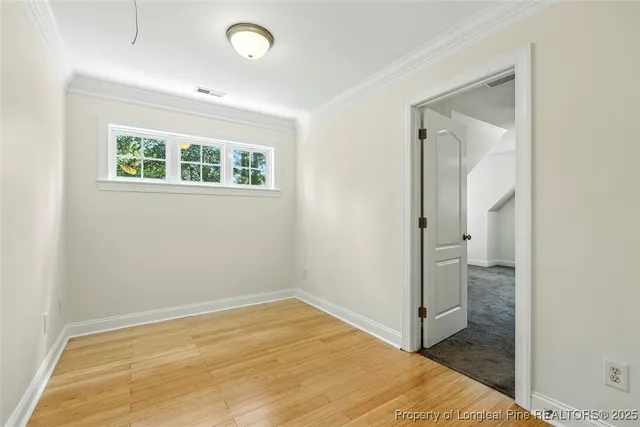 a view of empty room with wooden floor