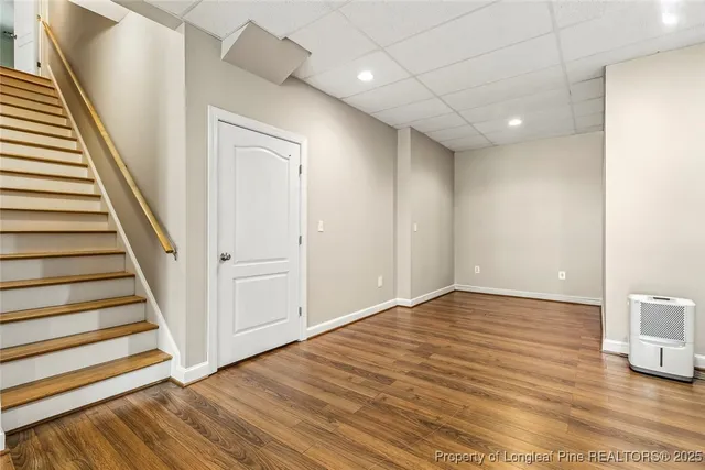 an empty room with wooden floor and natural light