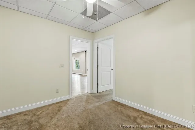 an empty room with windows and ceiling fan