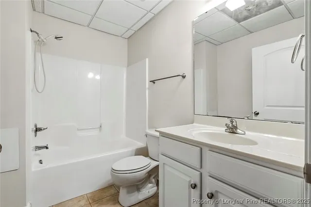 an empty room with a ceiling fan and carpet