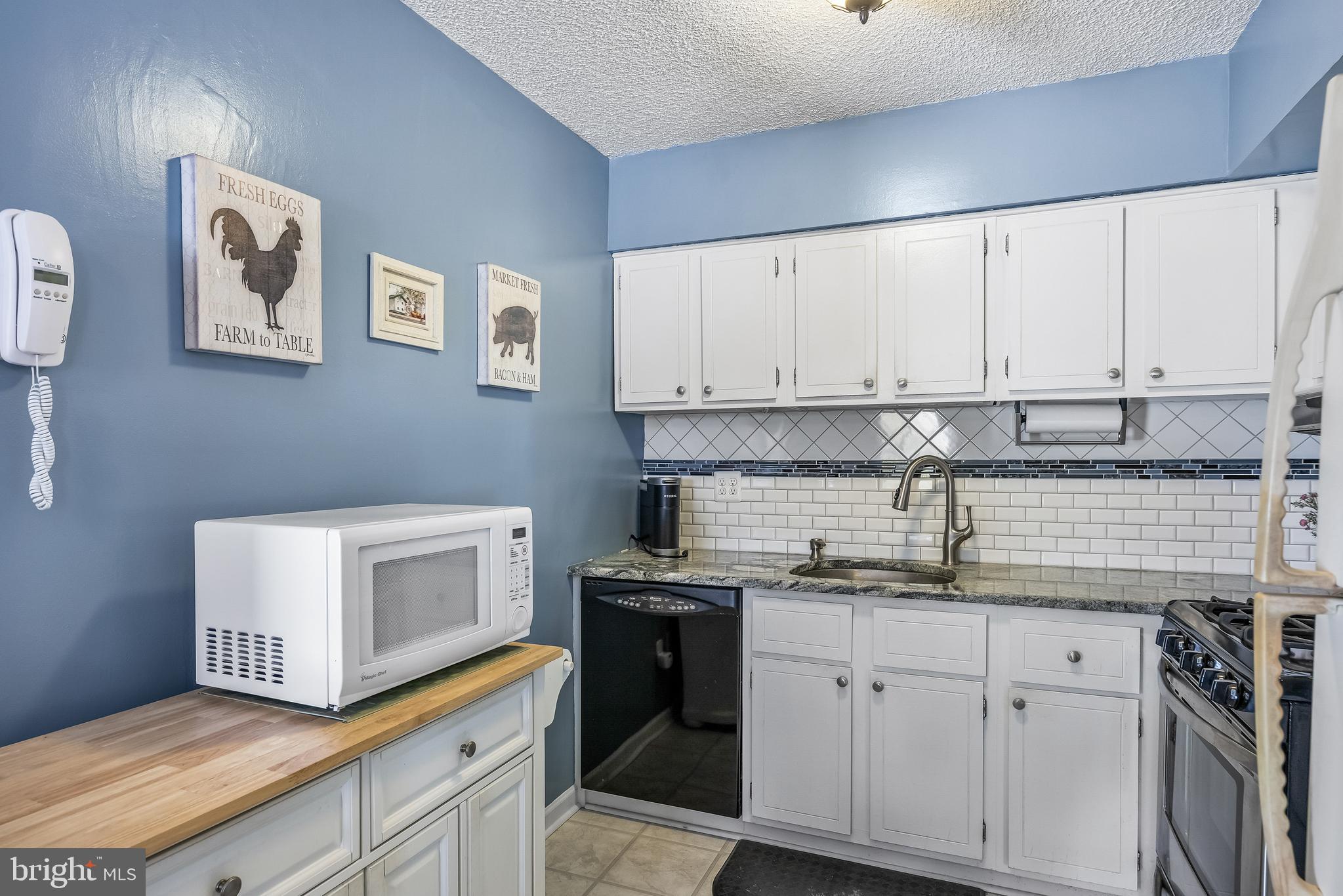 411 Stiles Avenue, Unit A2 Maple Shade, NJ 08052 - Photo 8 of 26 a kitchen with granite countertop white cabinets and white appliances