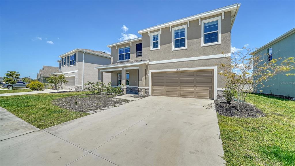 12732 Lateral Root Drive Sarasota, FL 34238 - Photo 2 of 76 a front view of a house with a yard and garage