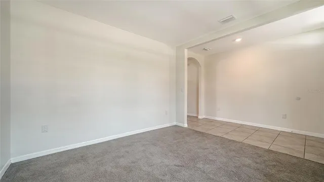 a view of kitchen with granite countertop cabinets and refrigerator