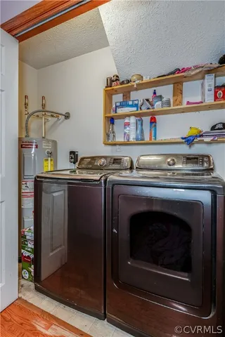 a utility room with stainless steel appliances wooden floor and a fireplace