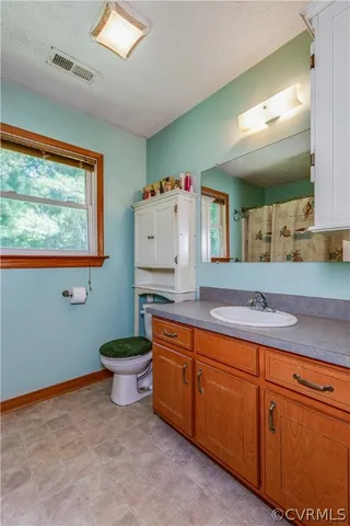 a bathroom with a granite countertop sink and a large mirror
