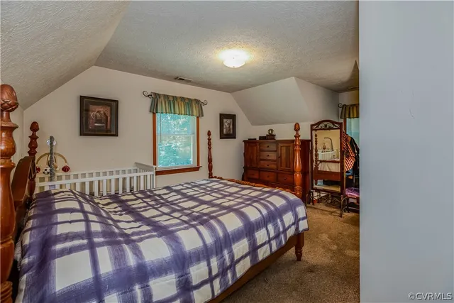 a bed sitting in a bedroom next to a window