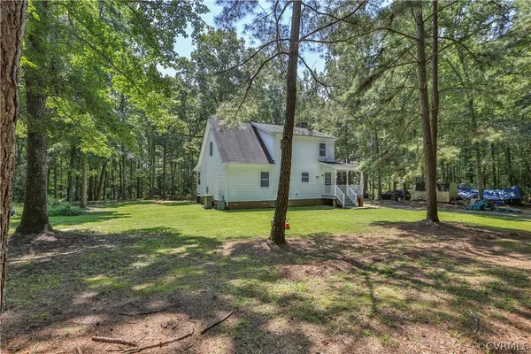 a view of a house with a backyard and a tree