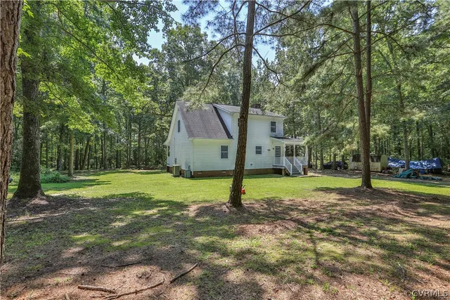 a view of a house with a backyard and a tree