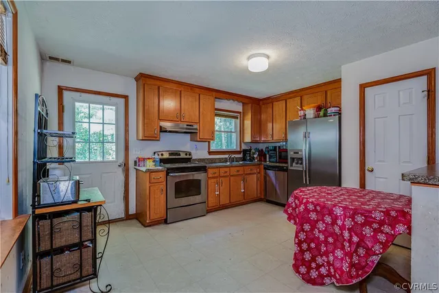 a kitchen with a refrigerator sink and cabinets