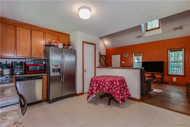 a kitchen with stainless steel appliances granite countertop a refrigerator and a stove top oven