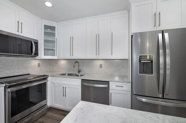 a kitchen with stainless steel appliances granite countertop a refrigerator stove and microwave