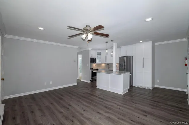 a view of kitchen with stainless steel appliances refrigerator stove microwave and cabinets