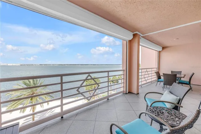 a view of a swimming pool with a table and chairs under an umbrella