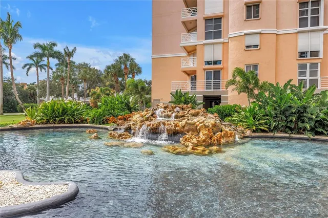 a view of a white house with a big yard and potted plants