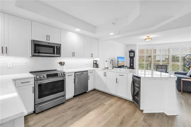 a kitchen with white cabinets and stainless steel appliances