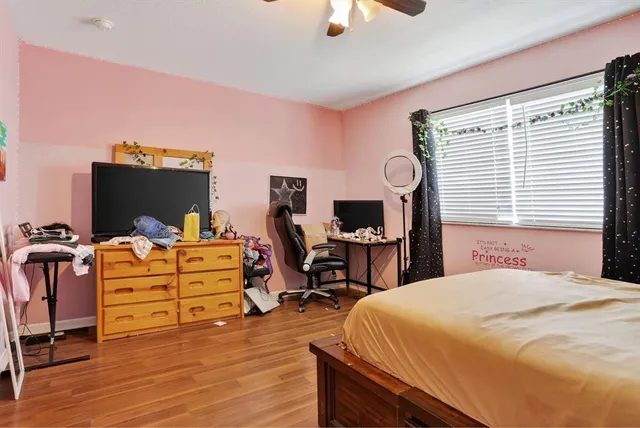 a bedroom with a bed and wooden floor