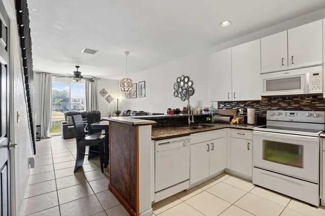 a kitchen with granite countertop cabinets a sink and appliances