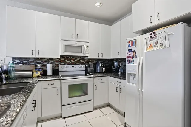a kitchen with white cabinets and white appliances