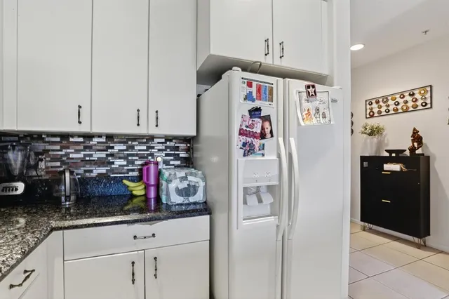 a kitchen with refrigerator and cabinets