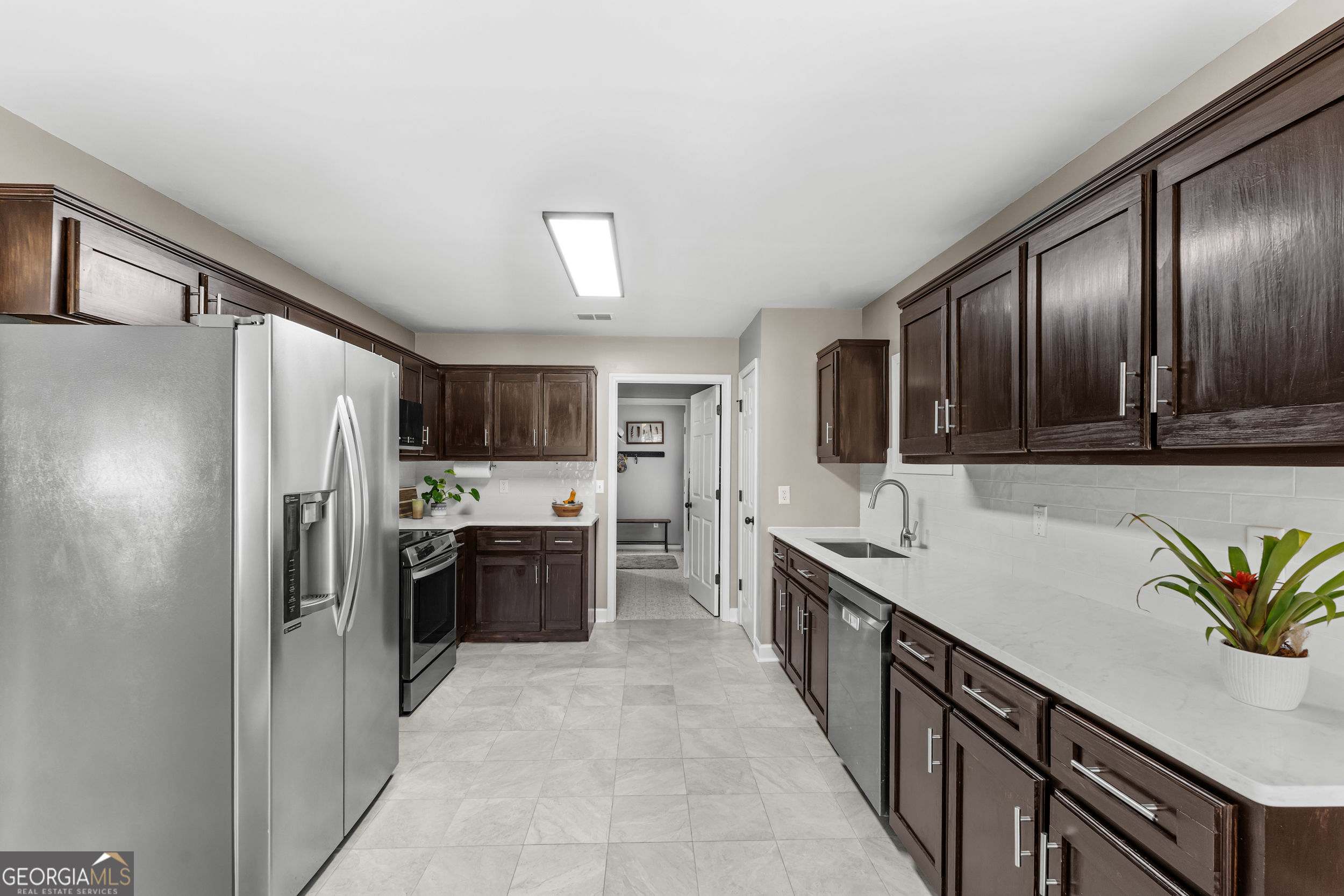 357 Pound Road Guyton, GA 31312 - Photo 13 of 49 a kitchen with stainless steel appliances a sink stove refrigerator and cabinets