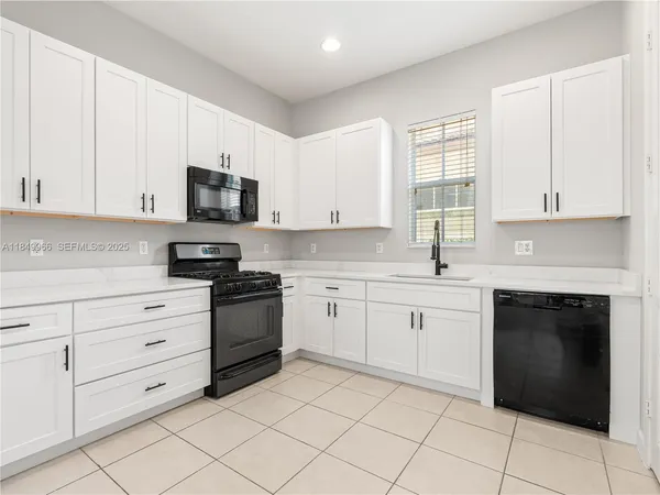a kitchen with cabinets appliances and a window