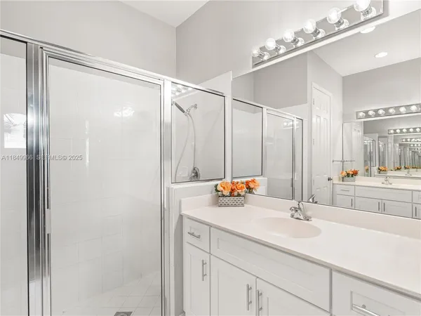 a bathroom with a double vanity sink mirror and shower