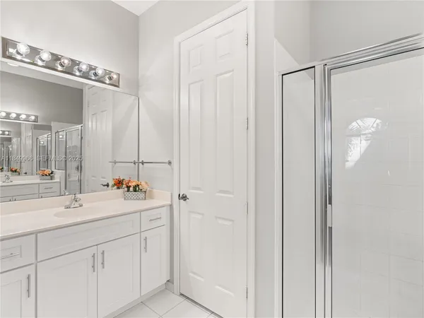 a bathroom with a double vanity sink mirror and shower