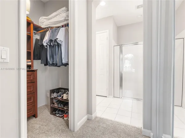 a view of walk in closet with clothes and shoes