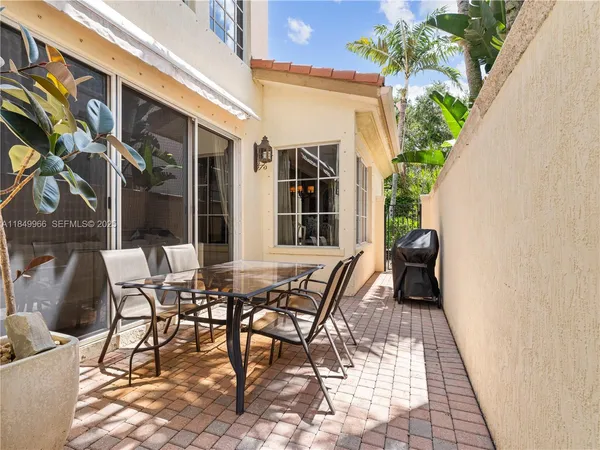 a view of a patio with table and chairs and potted plants