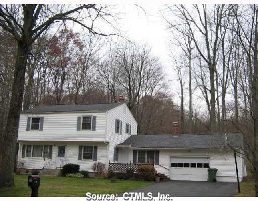 a front view of a residential houses with yard and trees