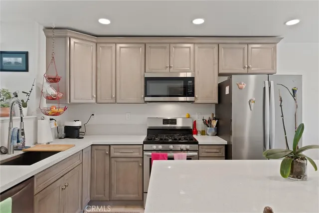 a kitchen with stainless steel appliances a stove a sink a refrigerator and cabinets