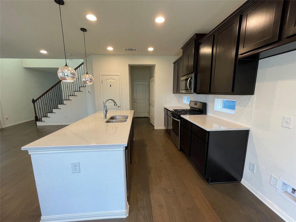 142 Simon Kyle, TX 78640 - Photo 3 of 16 a kitchen with kitchen island a sink stainless steel appliances and cabinets
