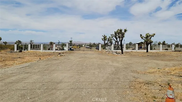a view of a dirt road with a building in the background