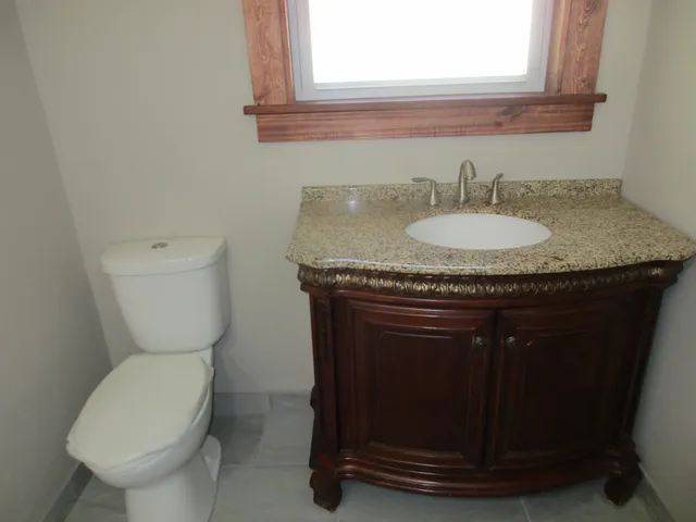 a bathroom with a toilet sink and mirror