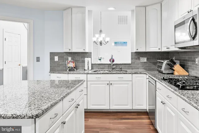 a kitchen with stainless steel appliances granite countertop a sink stove and cabinets