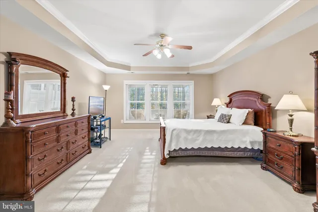a spacious bedroom with a large bed and a chandelier