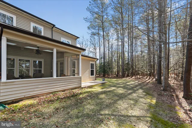 a view of a house with a yard and large tree